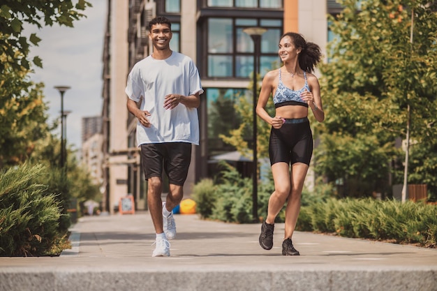 Dos jóvenes en ropa deportiva corriendo juntos