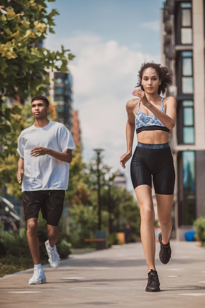 Dos jóvenes en ropa deportiva corriendo juntos