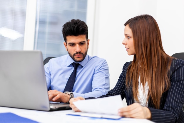 Dos jóvenes socios empresariales discutiendo planes o ideas en una reunión