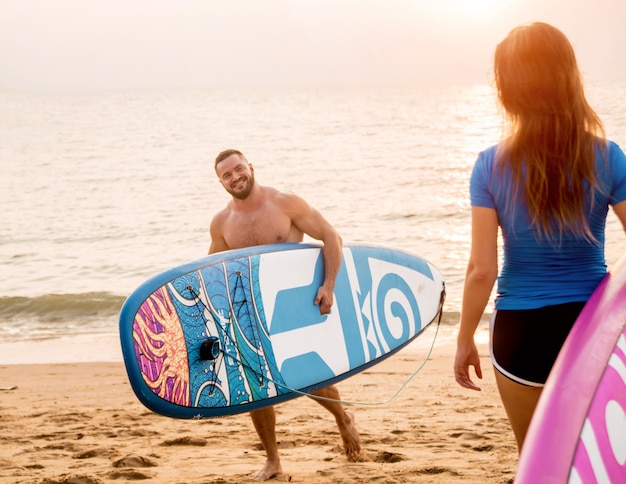 Dos jóvenes surfistas entrando al mar con tablas de surf