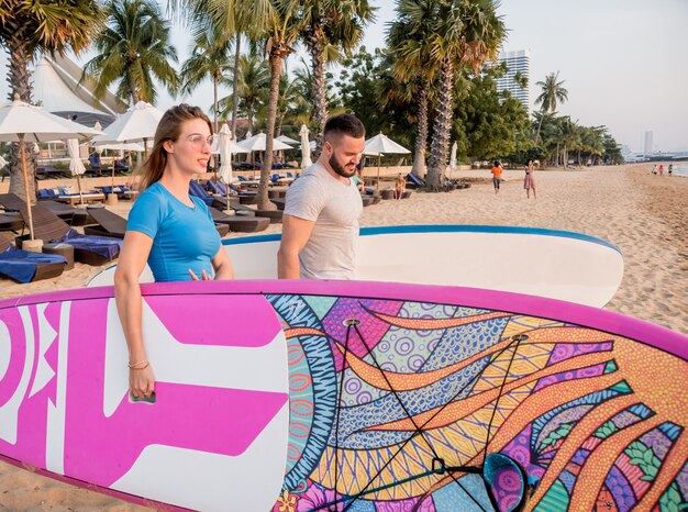 Dos jóvenes surfistas entrando al mar con tablas de surf