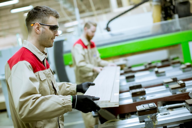 Foto dos jóvenes trabajando en la fábrica de muebles.