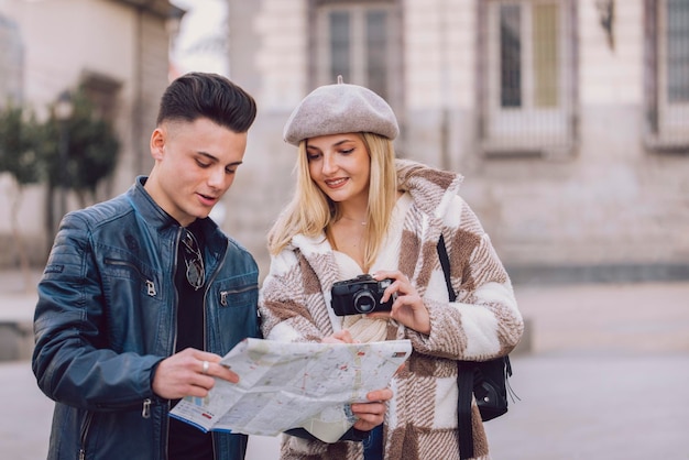 Foto dos jóvenes turistas miran el mapa mientras visitan la ciudad