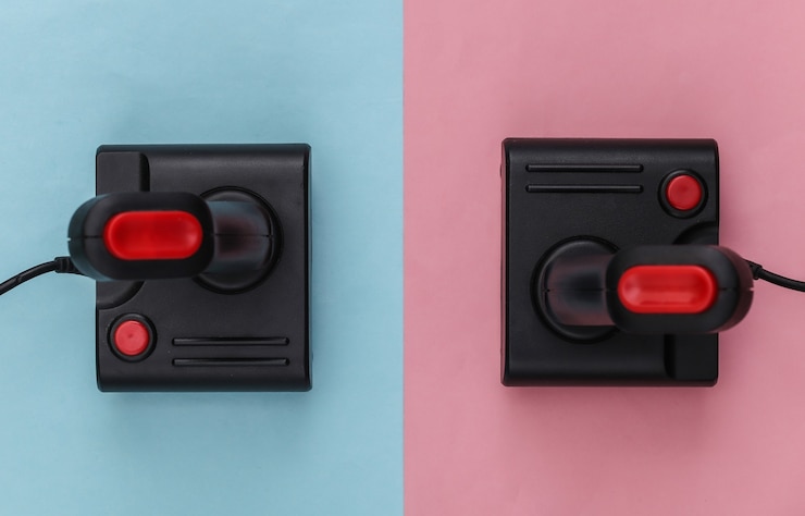 Foto dos joysticks retro sobre fondo azul-rosa. tendencia de color pastel. juegos, competición de videojuegos. vista superior, minimalismo