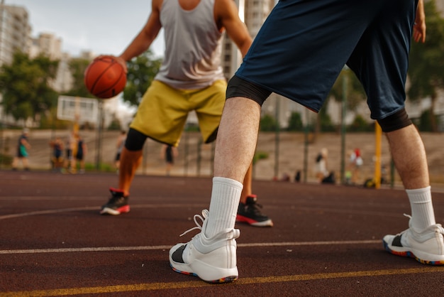 Dos jugadores en el centro del campo de baloncesto en cancha al aire libre.