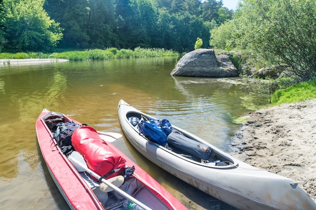 Dos kayaks de pie en el agua cerca de la orilla del río sin gente