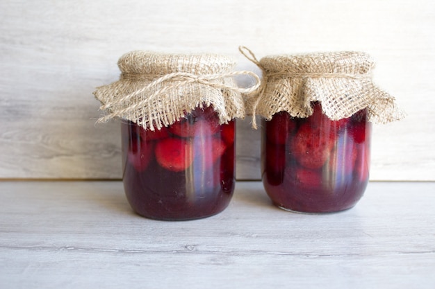 Dos latas de mermelada de fresa, conservas de frutas de verano