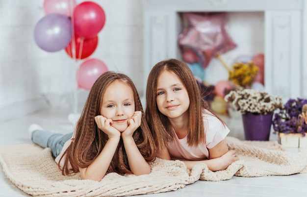 Dos lindas hermanas pequeñas se abrazan y ríen felizmente