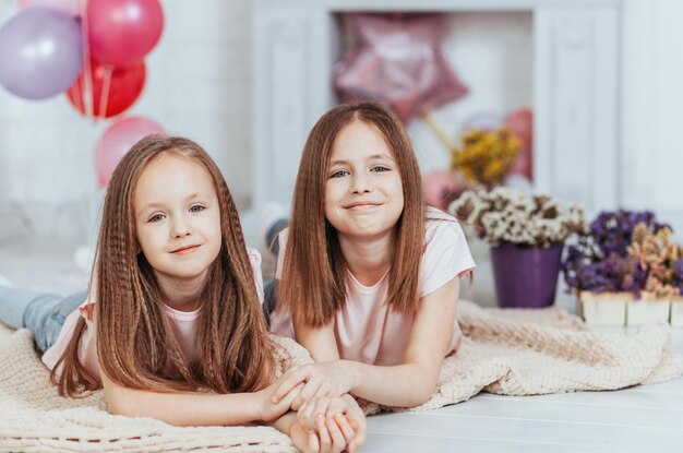 Dos lindas hermanas pequeñas se abrazan y ríen felizmente