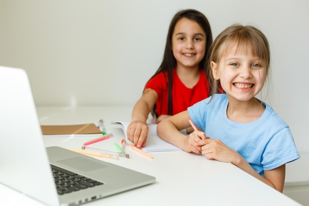 Dos lindas hermanitas estudian juntas en casa. Educación para niños.