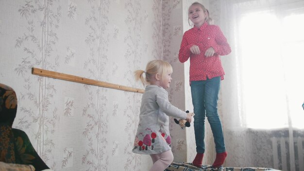 Dos lindos niños niñas jugando y divirtiéndose en la habitación de los niños