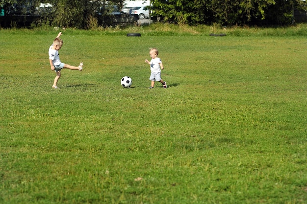 Dos lindos niños pequeños jugando al fútbol