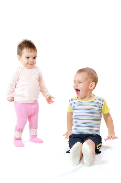 Dos lindos niños pequeños sentados y jugando.