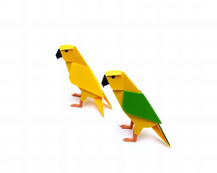 Foto dos loros origami simples de papel amarillo y verde aislados sobre un fondo blanco