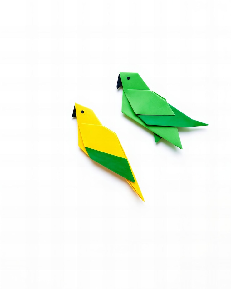 Foto dos loros origami simples de papel amarillo y verde aislados sobre un fondo blanco