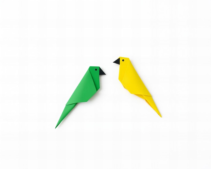 Foto dos loros origami simples de papel amarillo y verde aislados sobre un fondo blanco