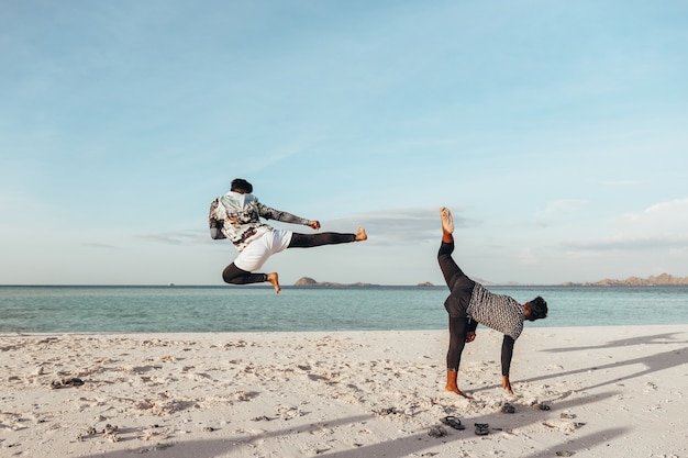 Dos luchadores entrenando en la playa.