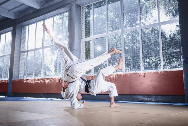 Dos luchadores de judo que muestran habilidad técnica mientras practican artes marciales en un club de lucha