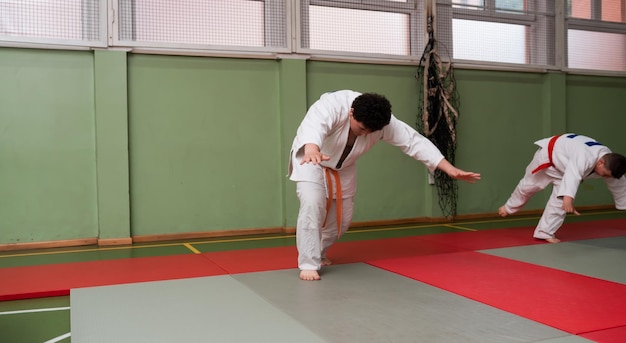 Dos luchadores de judo que muestran habilidad técnica mientras practican artes marciales en un club de lucha