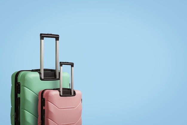 Dos maletas con ruedas sobre un fondo azul. Concepto de viaje, un viaje de vacaciones, una visita a familiares. Color rosa y verde