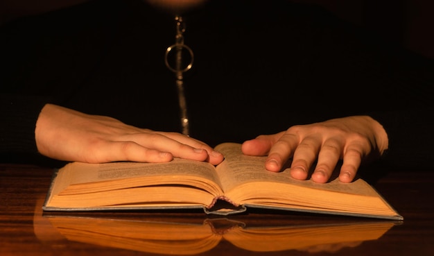 Foto dos manos sobre un libro sobre una mesa