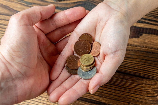 Dos manos sosteniendo monedas en las palmas.