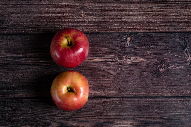Dos manzanas maduras sobre un fondo de madera marrón. Vista superior.