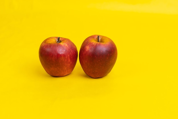 dos manzanas sobre fondo amarillo