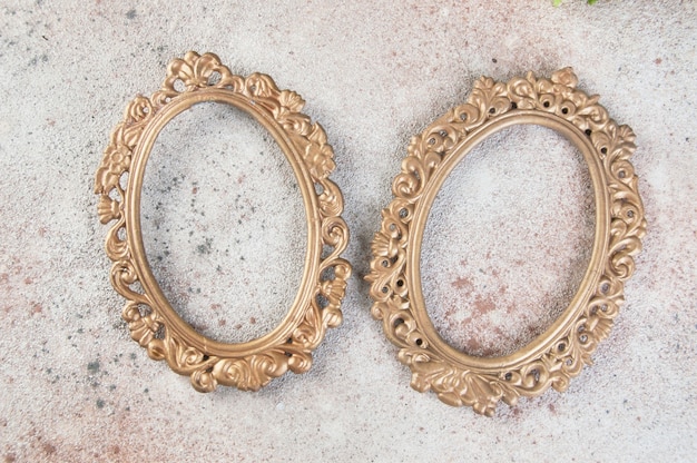 Dos marcos vacíos de latón antiguo sobre fondo de hormigón. Accesorios de fotografía y espacio para copiar texto.