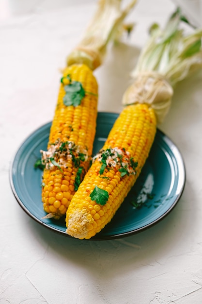 Dos mazorcas de maíz cubiertas con salsa