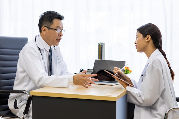 Dos médicos en el hospital discuten el diagnóstico del paciente.