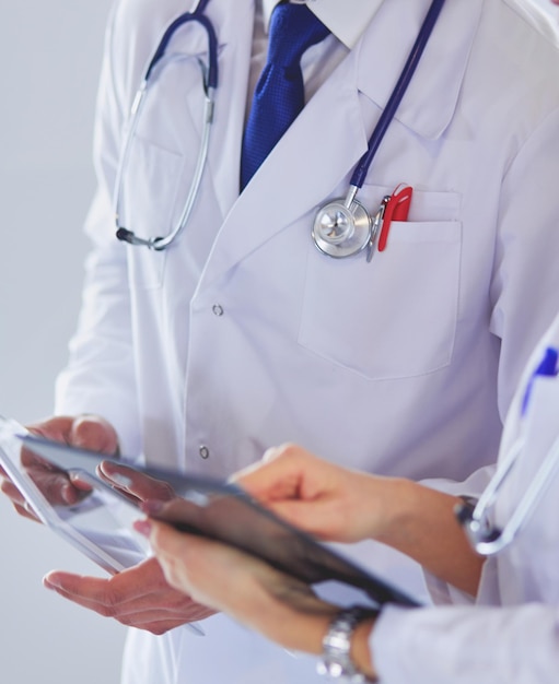 Dos médicos sosteniendo una carpeta y hablando de paciente