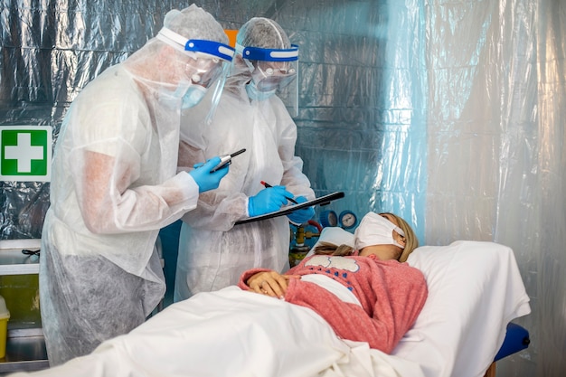 Foto dos médicos con trajes de protección están listos para hacer el diagnóstico. epidemia del coronavirus