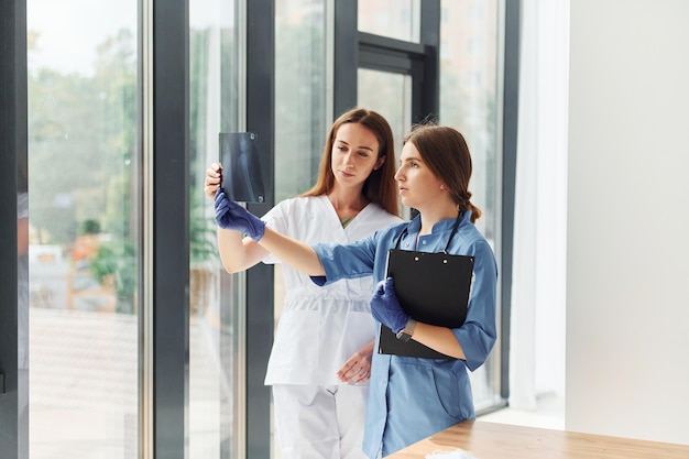 Dos médicos uniformados parados en el interior y trabajando juntos