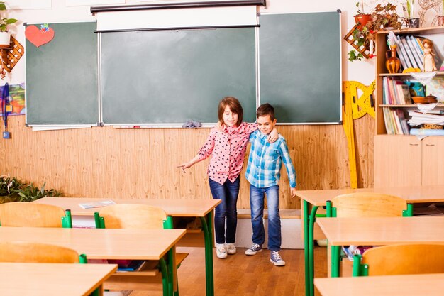 Dos mejores amigos abrazándose y divirtiéndose sonriendo en el aula