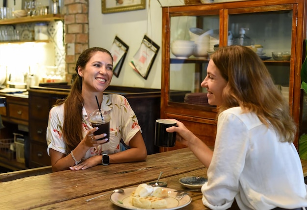 Dos mejores amigos hablando y bebiendo café en un café.