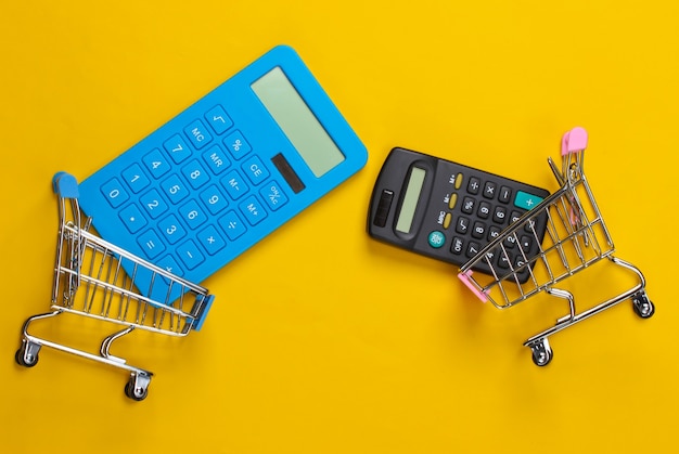 Dos mini carros de supermercado con calculadoras en amarillo