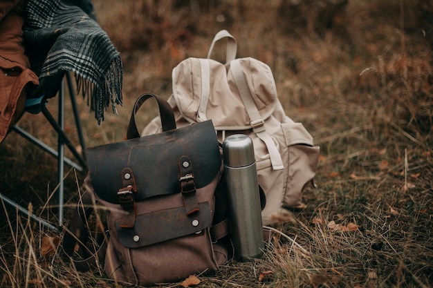 Dos mochilas de senderismo y un termo con té en el camping