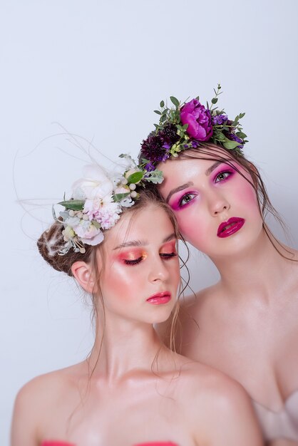 Dos modelos de belleza de moda con maquillaje brillante profesional.