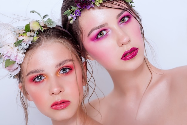 Dos modelos de belleza de moda con maquillaje brillante profesional.