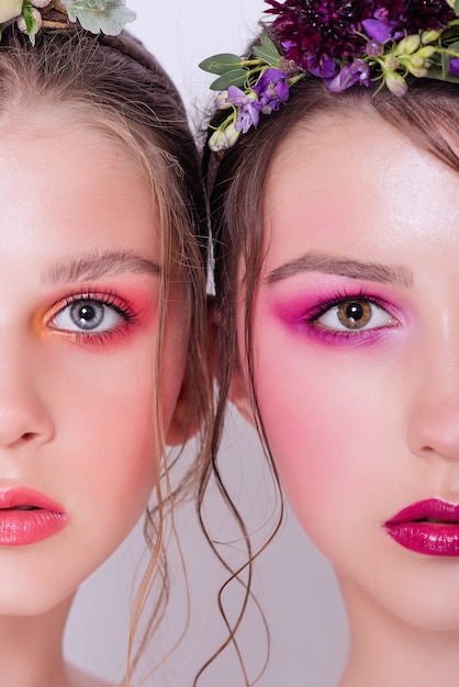 Dos modelos de belleza de moda con maquillaje brillante profesional.