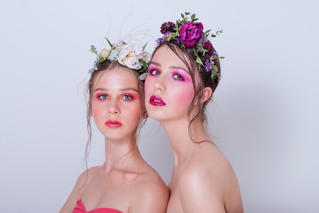 Dos modelos de belleza de moda con maquillaje brillante profesional.