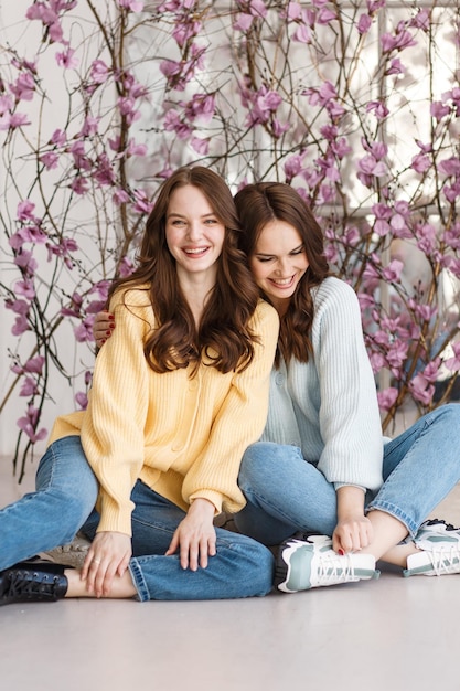 Dos modelos de chicas se divierten y sonríen en un estudio fotográfico Expresión de emociones