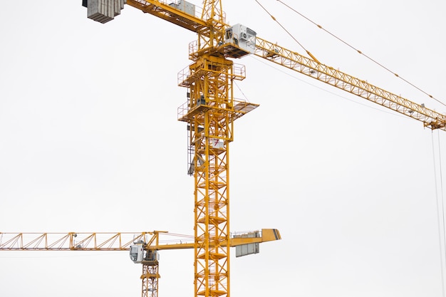 Dos modernas grúas de construcción amarillas sobre el cielo.