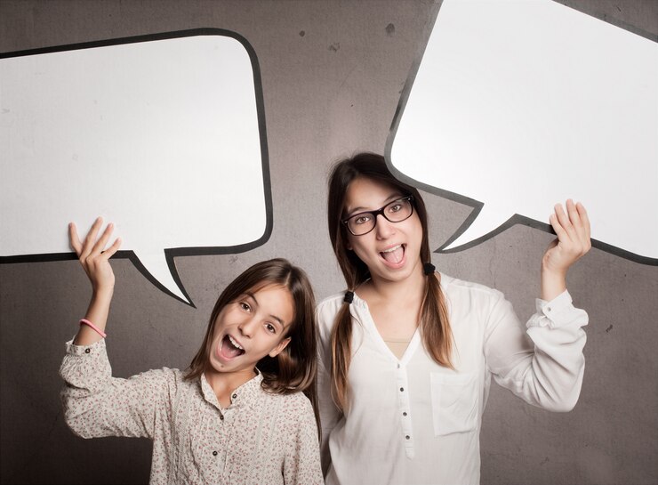 Foto dos muchachas felices que sostienen una burbuja del discurso