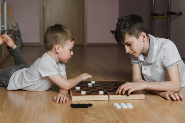 Dos muchachos jugando una partida de ajedrez en el suelo