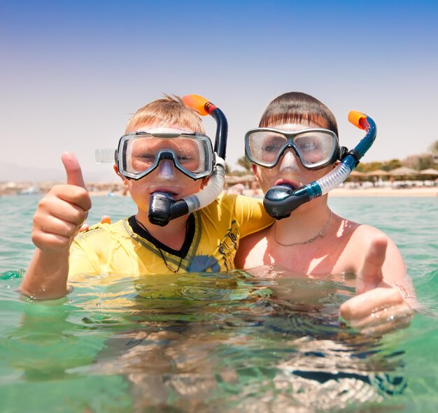 dos muchachos en el mar en una playa