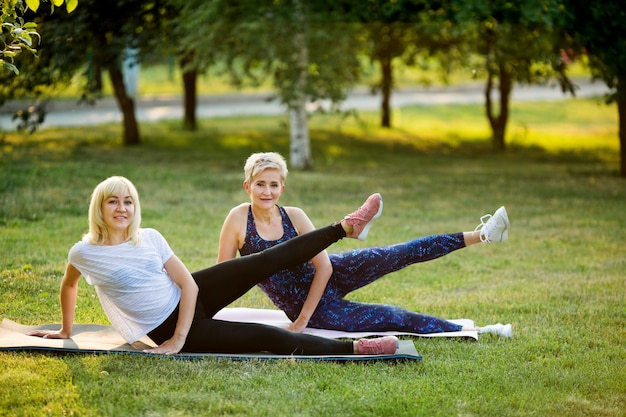 Dos mujeres adultas practican deportes en un parque de verano.