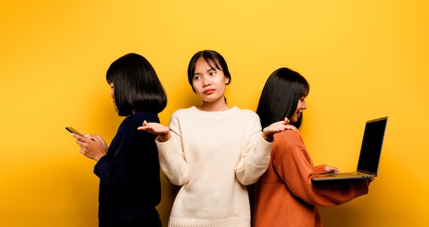 Dos mujeres asiáticas trabajando en una computadora portátil y un teléfono al mismo tiempo dos de ellas se comunicaban en línea