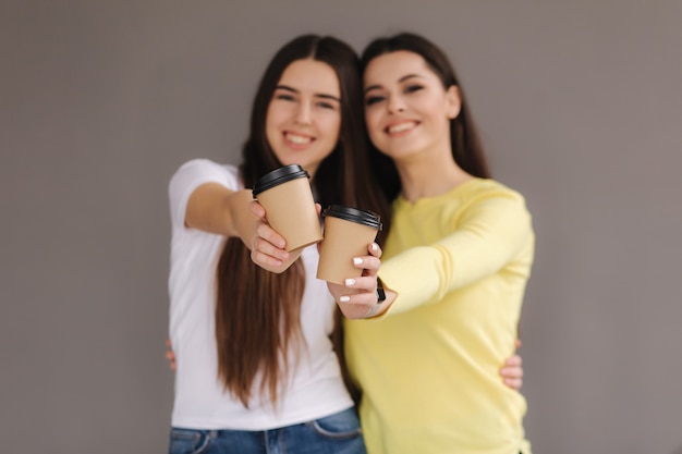 Foto dos mujeres atractivas sostienen una taza de café